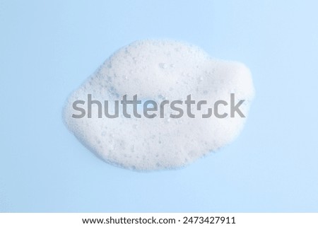 Sample of fluffy foam on light blue background, top view
