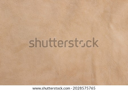 Sample of genuine calfskin of the highest quality. Beige leather texture or background.