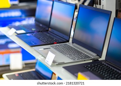 A sample of laptops in a shop window behind glass on a blurred background.