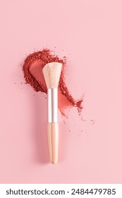 A sample of loose delicate makeup blush and a brush to apply on a pink background. vertical top view. A copy space. layout, design