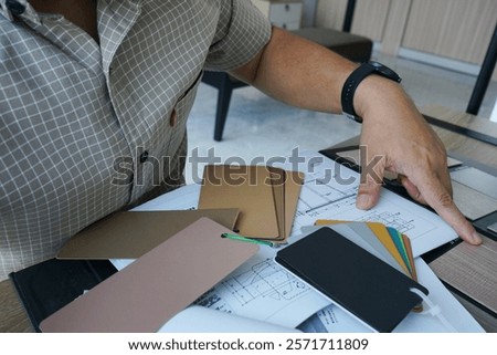 Sample materials for the interior are being selected by an interior designer, as a consideration in determining the choice.