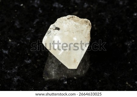 sample of raw topaz crystal on black granite background close up from Transbaikalia, Russia