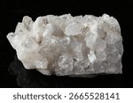sample of rough druse of clear quartz rock on black granite background close up from China