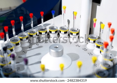 Sample tubes are placed in tray of automated NMR spectroscopy instrument. The samples are arranged by number to form a queue for automatic analysis preparing to identify structure of organic molecules