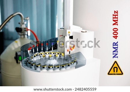 Sample tubes are placed in a tray to be analyzed by an automated NMR spectroscopy at 400 MHz. Additionally, the yellow symbol indicates a warning for high magnetic field strength in the instrument.