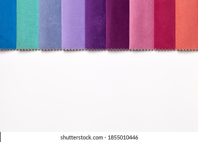 Sample of velvet textile various colors, background on white table with copy space. Catalog and palette tone of Interior fabric for furniture, closeup. Collection of multicolored cloth.