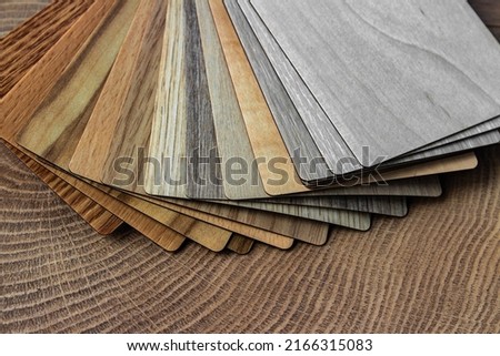 Sample of wood laminated chipboard for furniture design on wooden background with copy space. Color guide displaying a range of hues for use in interior design and decoration, for designers