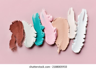 Samples Of Color Correcting Concealers Set On Pink Background. Swatch Smears Of Cream Makeup Base