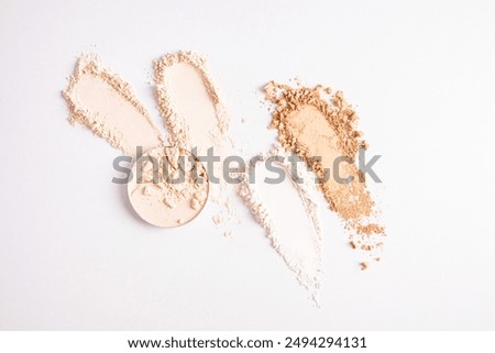Samples of compact powder and loose powder of different tones, strokes, blocks on a white background. top view. texture of various powders. layout