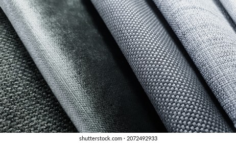 samples of curtain or drapery fabric. production of upholstered for furniture furnishing, details. macro view photo, selective focus at grey fabric texture. grey and white fabric samples swatch.