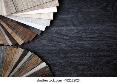 Samples of laminate and vinyl floor tile on wooden Background
