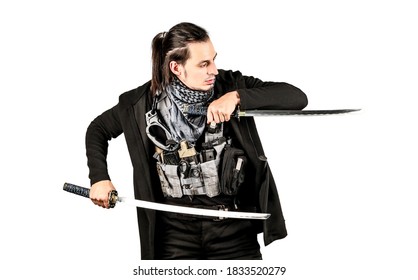 Samurai with ponytail haircut holding dual katanas in his hands aiming with blades to the right. He dressed in long black hooded coat, grey tactical vest with gadgets. Isolated, white background.
