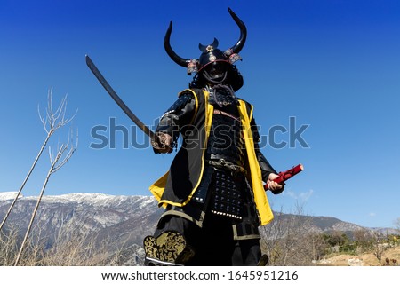 Samurai warrior dressed in armor, posing in the mountain