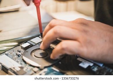 Samut Prakan, Thailand - February, 2019: Dell laptop repair technician removing components from the laptop assembly to perform the required maintenance