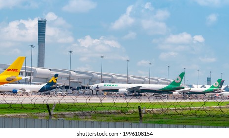 SAMUT PRAKAN, THAILAND-MAY 15, 2021 : Cargo aircraft parked at airfield in the airport near airport terminal. Cargo plane of EVA Air, K-Mile Air, and DHL Express. Air logistic business. Air cargo.