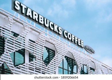 Samut Sakhon, Thailand - November 21,2020 : Low Angle And Side View Of Starbucks Coffee Drive Thru Label On Top Of The Old White Building In Modern Style Against Cloud With Blue Sky