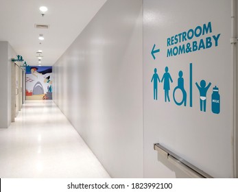 Samutsakhon, Thailand - April 27,2020 : Side View Of Blue Disabled Wheelchair And A Family Restroom Sign On White Modern Wall In Clean Corridor Inside Of Shopping Mall Area