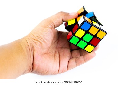 SAMUT-SAKHON, THAILAND - AUGUST 29, 2021 : Hand Holding Rubik's Cube Puzzle Isolated On White Background, Illustrative Editorial.