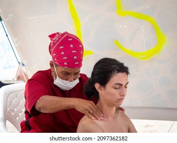 San Andres, Colombia - November 17 2021: Black Woman In Mask Gives Back Massage To Young Woman 