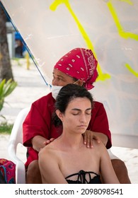 San Andres, Colombia - November 17 2021: Black Woman In Mask Gives Back Massage To Young Woman 