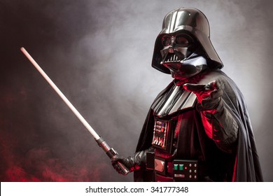 SAN BENEDETTO DEL TRONTO, ITALY. MAY 16, 2015. Portrait of Darth Vader costume replica with grab hand and  sword . Lord Fener is a fictional character of Star Wars saga.  Red grazing light and smoke 