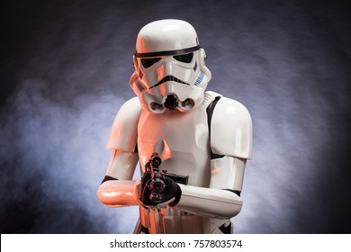 SAN BENEDETTO DEL TRONTO, ITALY. NOVEMBER 11, 2017. Studio portrait  of stormtrooper costume replica, with blaster E-11 gun. He is a fictional character of Star Wars saga. Blue background with smoke