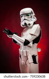 SAN BENEDETTO DEL TRONTO, ITALY. NOVEMBER 11, 2017. Studio portrait  of stormtrooper costume replica, with blaster E-11 gun. He is a fictional character of Star Wars saga. Red background with smoke