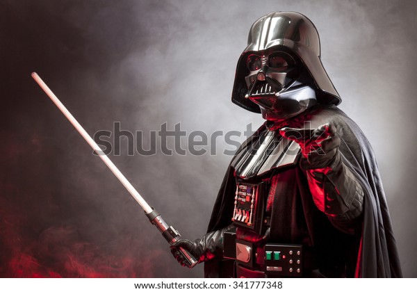 SAN BENEDETTO DEL TRONTO, ITALY. MAY 16, 2015. Portrait\
of Darth Vader costume replica with grab hand and  sword . Lord\
Fener is a fictional character of Star Wars saga.  Red grazing\
light and smoke 