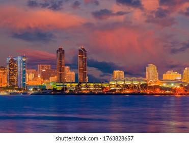 San Diego Bay is filled with color from the sunset and night lights of the San Diego skyline.