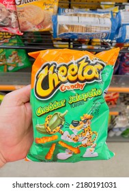 San Diego, CA - July 2, 2022: Hand Holding A Bag Of Cheetos Crunchy Cheddar Jalapeño Corn Chips.