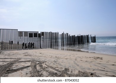 SAN DIEGO, CA- OCTOBER 16: Unidentified people stand at the end of the border between USA and Mexico on Oct. 16, 2011 in San Diego, CA. They are in Tijuana, Mexico, separated by a fence that goes into the Pacific Ocean.