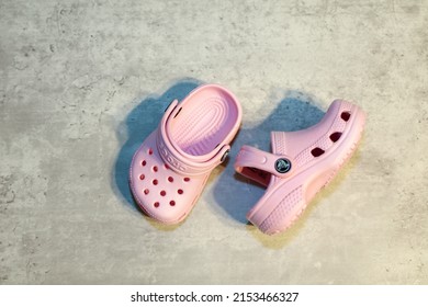 San Diego, CA - USA: April 29, 2022: Top and side view of a pair of light pink baby Crocs. Popular Children's shoes made out of foam.
