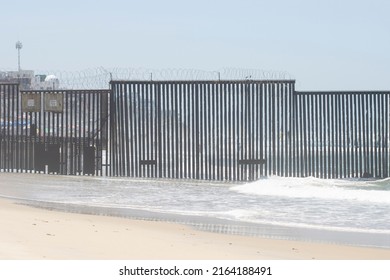 San Diego, CA, USA - May 14, 2022: The border fence between the U.S. and Mexico seen from the beach in Border Field State Park. It separates San Diego from Tijuana and extends into the Pacific Ocean.