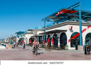 SAN DIEGO, CALIFORNIA - FEBRUARY 9, 2018:  People Bike And Walk Along The Mission Beach Concrete Boardwalk, Which Is Lined With Shops, Restaurants And Is The Location Of Belmont Park Amusement Park.  