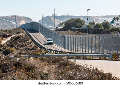 San Diego, California and Tijuana, Mexico international border wall with border patrol vehicle. 