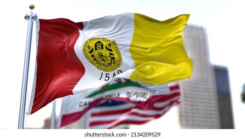 San Diego city flag waving in the wind with California state and United States national flags blurred in background. San Diego municipal flag