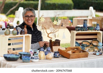 San Diego Vintage Collective Art and Craft Show booth Dec 5 2021 woman with pottery display selling her ceramic bowls, vases, dishes, and ornaments at the crafts fair                   - Shutterstock ID 2096747068
