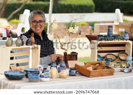 San Diego Vintage Collective Art and Craft Show booth Dec 5 2021 woman with pottery display selling her ceramic bowls, vases, dishes, and ornaments at the crafts fair                  