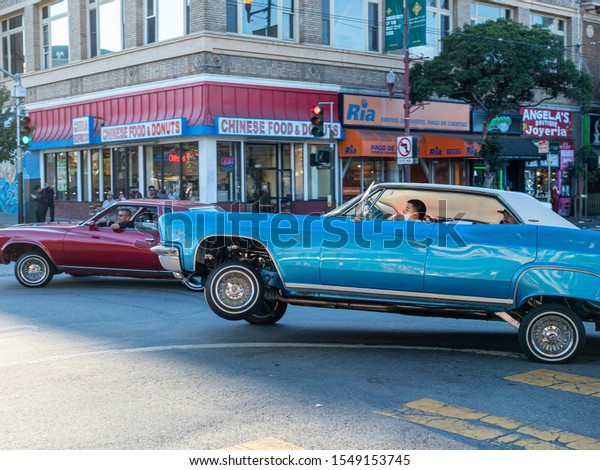 San Francisco, CA AUGUST 31, 2019: Low rider\
Chevrolet Caprice car rounding corner mid-bounce, showing\
suspension and rims