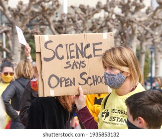 San Francisco, CA - Mar 13, 2021: Unidentified participants at the Open the Schools Rally at Civic Center in front of City Hall, holding signs in protest of schools still being closed in the city.