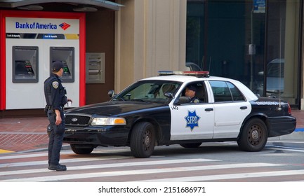 San Francisco, CA - May 1, 2022: SFPD Police officers standby as Unidentified participants marching up Market Street celebrating May Day, also known as International Workers’ Day.