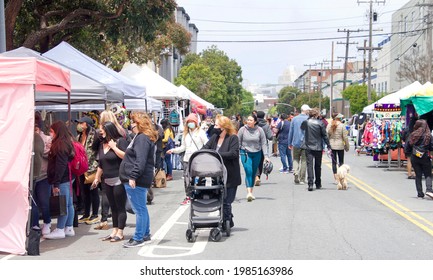 San Francisco, CA - May 29, 2021: Unidentified participants at Carnaval Festival in the Mission Distric, walking down the main street lined with venders selling their goods.