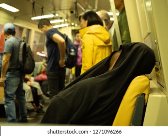 San Francisco, CA October 6, 2018: Man Sleeps With Shirt Over His Head On A Crowded BART Subway Car