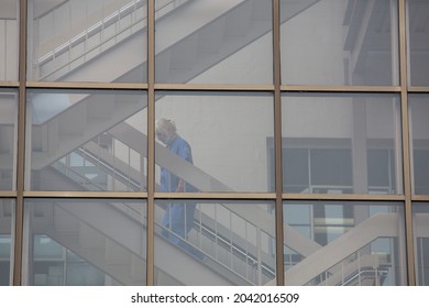 San Francisco, CA, USA, 9 11 2021, A Tired Female Medic In A Mask Walking In The Hospital Behind The Glass Walking Up The Stairs