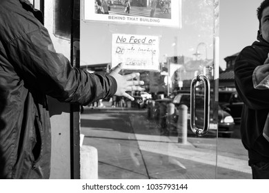 SAN FRANCISCO, CA, USA - FEBRUARY 25, 2018: In An Act Of Kindness, A Person Holds The Door Open For Another.