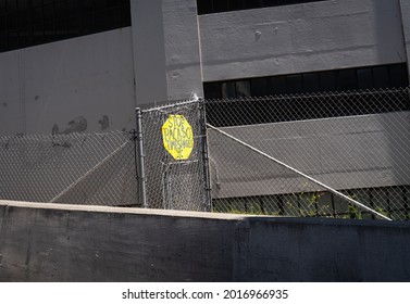 SAN FRANCISCO, CA U.S.A. - JULY 14, 2021: Street photograph image with bright fluorescent yellow stop protest sign that says Stop Pacaso Timeshares against a concrete garage on a freeway entrance.