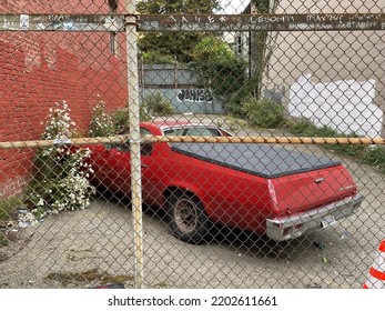 San Francisco, CA, USA - March 19, 2022 : View Of A Red El Camino Car Parked Near Bushes Behind A Fence On Hyde Street In Downtown SF