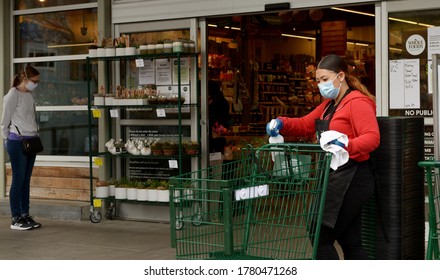 San Francisco, Calif., USA. April 12, 2020. A Whole Foods Worker Disinfects Shopping Carts April 12. Businesses Have Had To Adapt To New Rules Amid The Covid-19 Pandemic. Photo By Stephen Dorian Miner