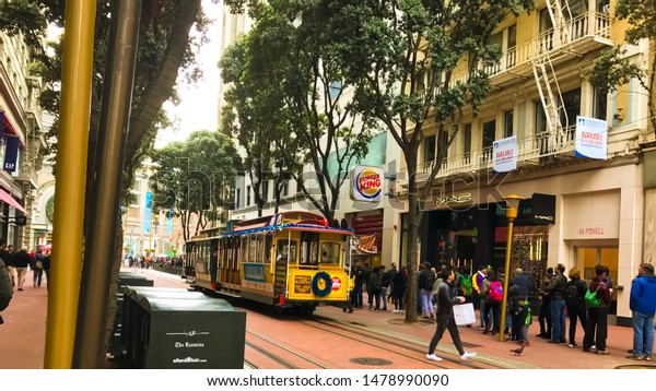 SAN FRANCISCO, CALIFORNIA - DECEMBER 31, 2016: \
cable car ride in san francisco downtown. people hang in the old\
tram on the cable car in the city of San Francisco, close up view.\
retro concept