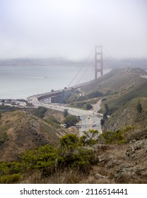 San Francisco, California - July 9, 2021 : US Highway 101 crossing the Golden Gate Bridge with haze and fog in the Bay. Seen from Slackers Hill on the Marin Headlands - selective focus